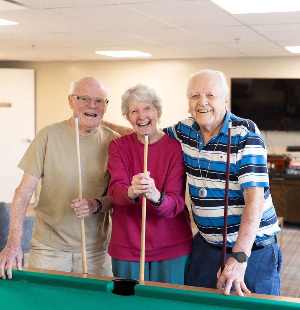 smiling residents playing pool
